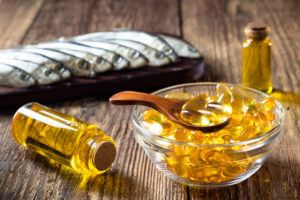 Fish oil capsules on wooden background, vitamin D supplement